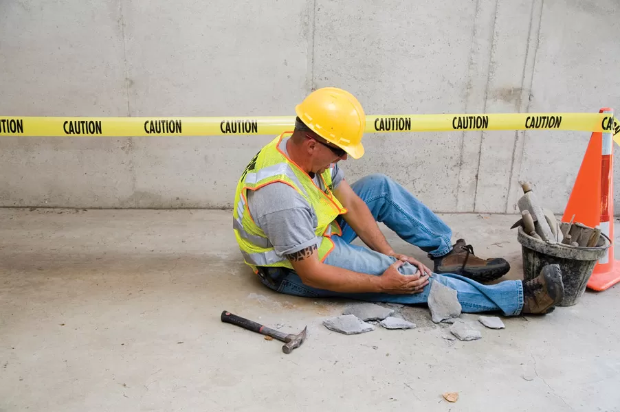 construction worker clutching injured knee